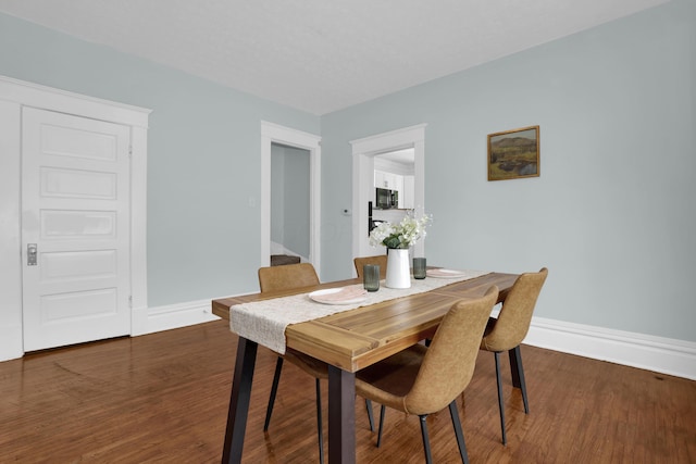 dining space with wood finished floors and baseboards