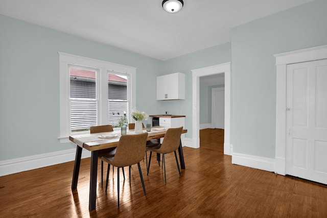 dining area with baseboards and dark wood-style floors