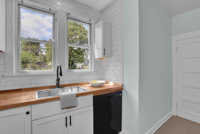 kitchen with butcher block countertops, dishwasher, a sink, and tasteful backsplash