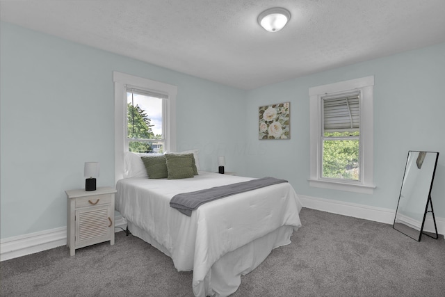carpeted bedroom with baseboards and a textured ceiling