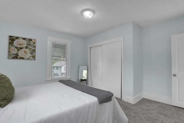 bedroom with carpet flooring, a closet, and baseboards