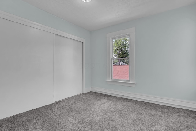 unfurnished bedroom with carpet and a closet