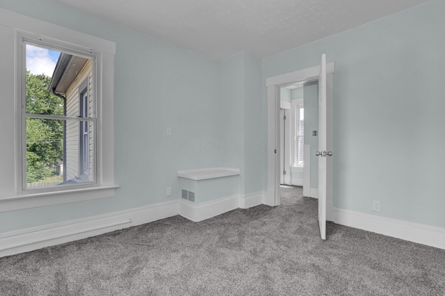 unfurnished room featuring carpet flooring and baseboards