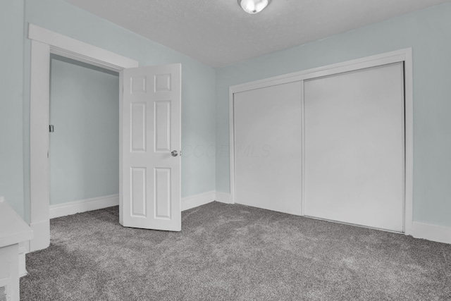unfurnished bedroom with carpet floors, a closet, and baseboards