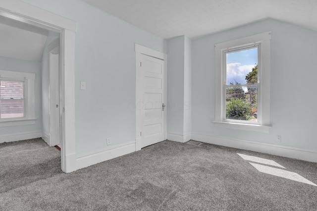 unfurnished bedroom featuring carpet, vaulted ceiling, and baseboards