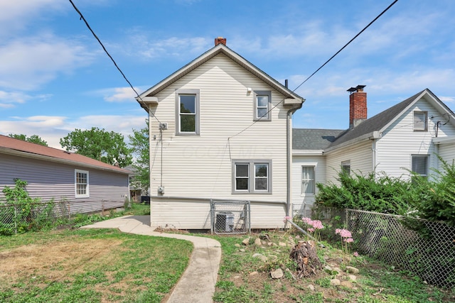 rear view of house featuring a chimney