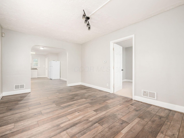 84 Meek Ave, Columbus, OH 43222 - spare room featuring arched walkways, wood finished floors, baseboards, and a textured ceiling