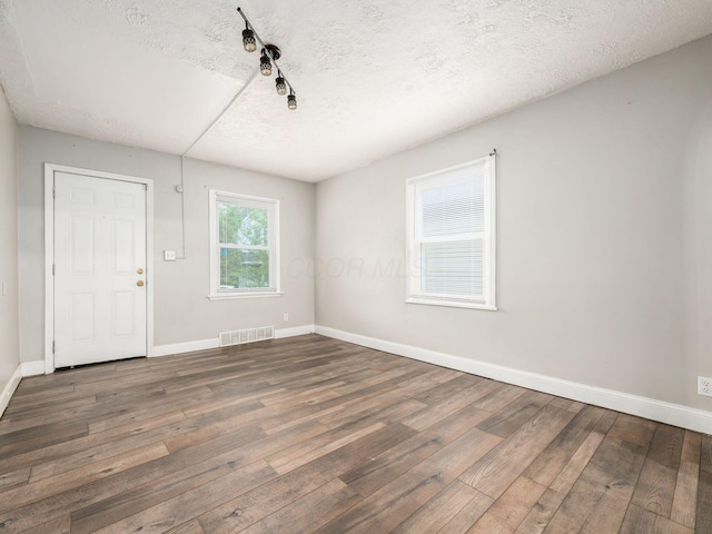 84 Meek Ave, Columbus, OH 43222 - empty room featuring a textured ceiling, wood finished floors, baseboards, and rail lighting