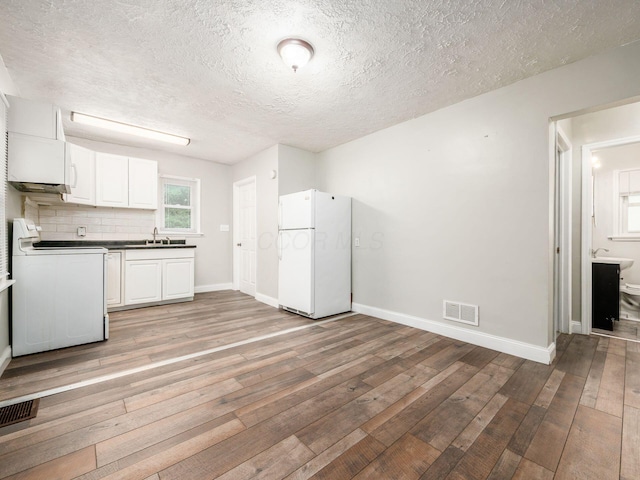 84 Meek Ave, Columbus, OH 43222 - kitchen featuring white appliances, a sink, light wood-style floors, baseboards, and a textured ceiling