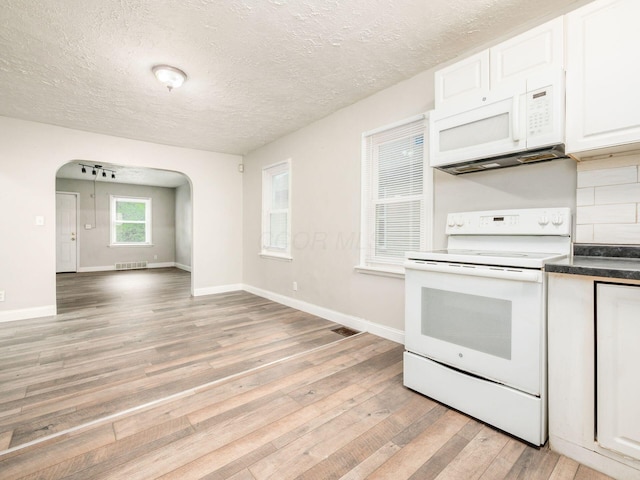 84 Meek Ave, Columbus, OH 43222 - kitchen with white appliances, arched walkways, light wood-type flooring, white cabinetry, and dark countertops
