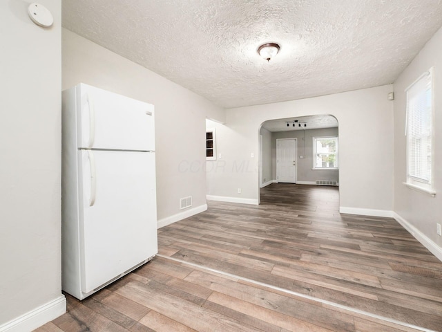 84 Meek Ave, Columbus, OH 43222 - unfurnished room with arched walkways, wood finished floors, a textured ceiling, and baseboards