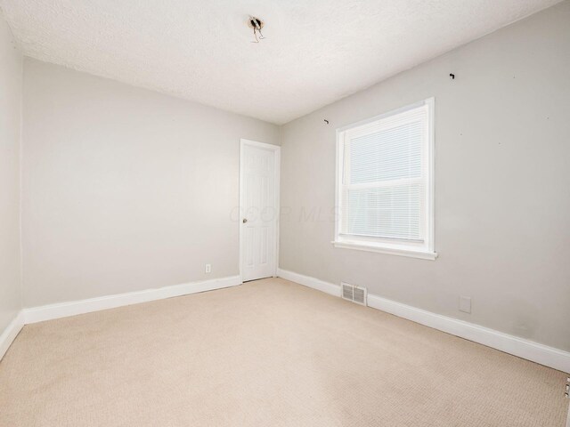 84 Meek Ave, Columbus, OH 43222 - empty room featuring light carpet, baseboards, and a textured ceiling