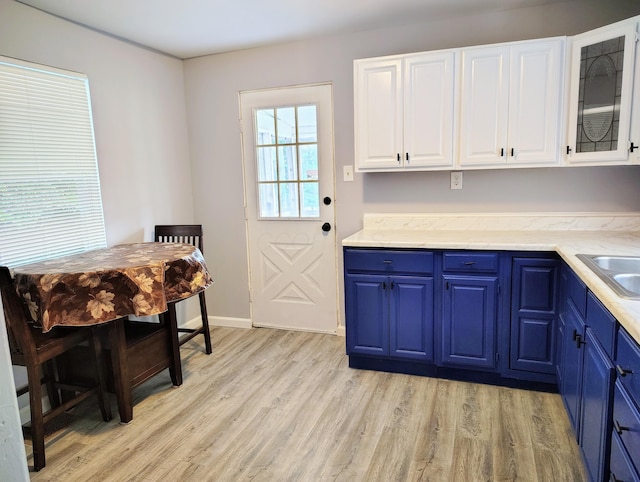 773 S Wayne Ave, Columbus, OH 43204 - kitchen with blue cabinets, light wood-type flooring, white cabinets, and glass insert cabinets