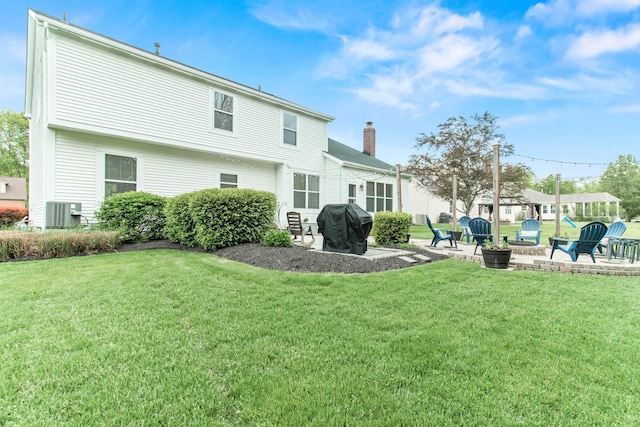 2668 Skelton Ln, Blacklick, OH 43004 - back of property with a patio area, a fire pit, a chimney, and a lawn