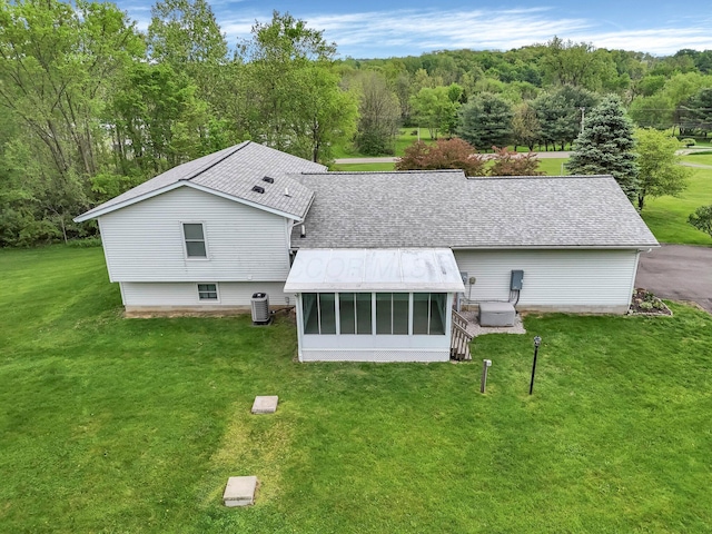 6301 Columbus Rd, Centerburg, OH 43011 - rear view of property with a sunroom, a shingled roof, a yard, and central AC