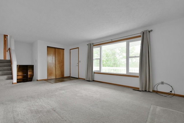 6301 Columbus Rd, Centerburg, OH 43011 - unfurnished living room featuring carpet floors, baseboards, stairway, and a textured ceiling