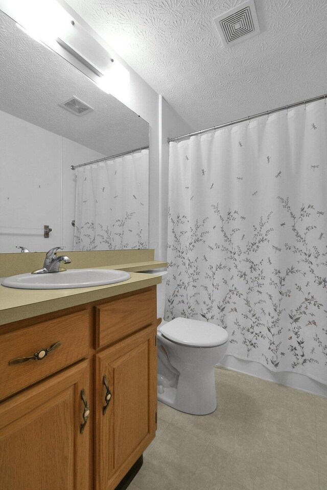 6301 Columbus Rd, Centerburg, OH 43011 - full bath featuring a textured ceiling, toilet, tile patterned floors, vanity, and curtained shower