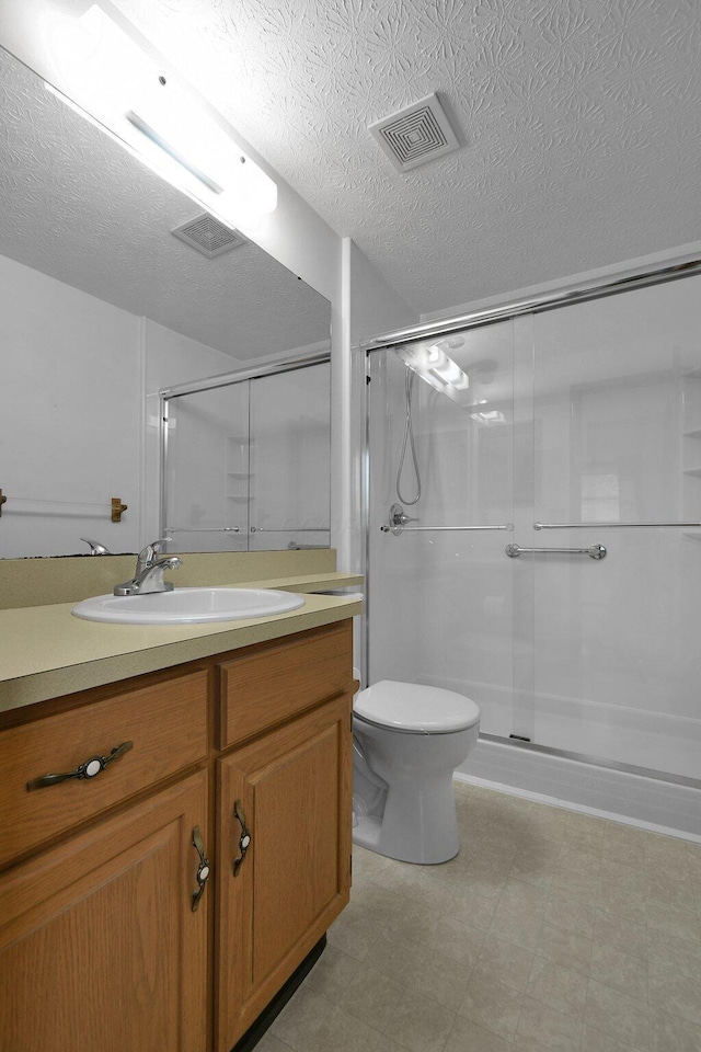 6301 Columbus Rd, Centerburg, OH 43011 - bathroom with tile patterned floors, a shower stall, vanity, toilet, and a textured ceiling