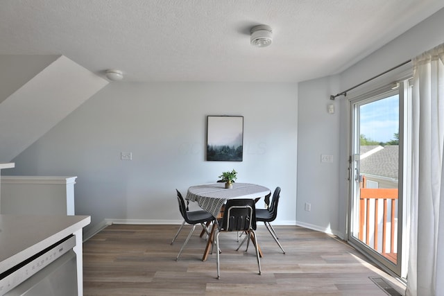 524 Autumn Ridge Cir, Pickerington, OH 43147 - dining space featuring light wood-style flooring, a textured ceiling, baseboards, and vaulted ceiling