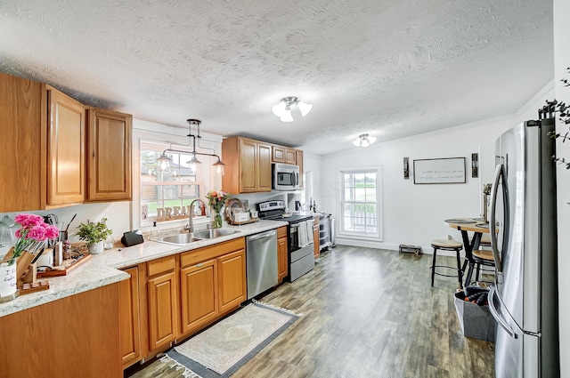 6125 Stafford Rd, Washington Court House, OH 43160 - kitchen with a sink, appliances with stainless steel finishes, wood finished floors, a textured ceiling, and pendant lighting