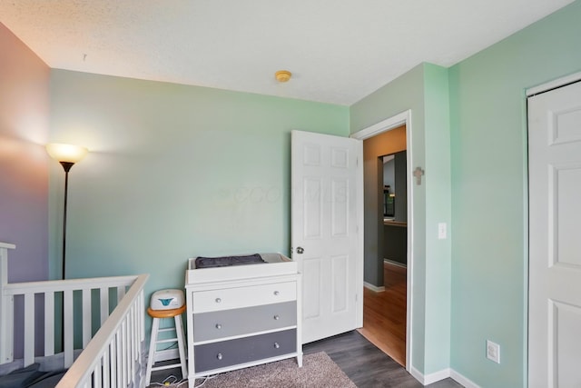 6963 Weurful Dr, Canal Winchester, OH 43110 - bedroom with dark wood-style flooring, a nursery area, and baseboards
