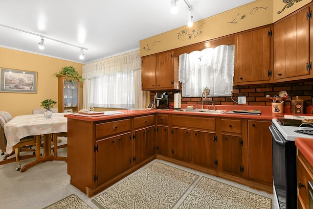 2116 Dunzweiler Dr, Zanesville, OH 43701 - kitchen with track lighting, a sink, range with electric stovetop, and brown cabinets