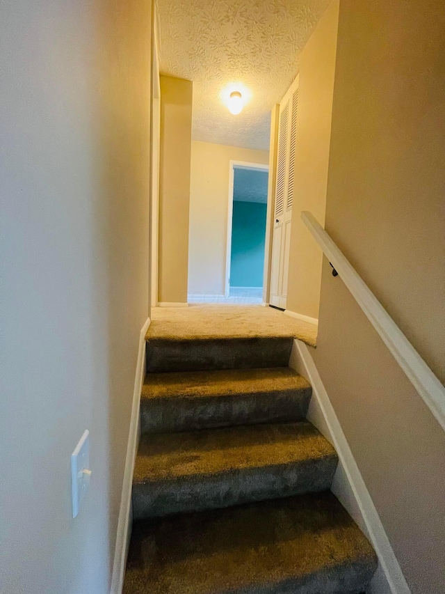 1275 Hathersage Pl, Galloway, OH 43119 - stairs featuring carpet floors, a textured ceiling, and baseboards