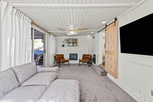 11526 Horseshoe Channel Dr, Lakeview, OH 43331 - living area featuring light colored carpet, a barn door, heating unit, ceiling fan, and wood ceiling