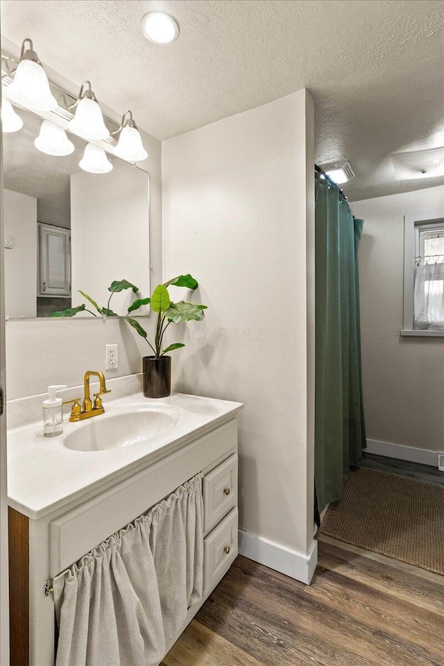 11526 Horseshoe Channel Dr, Lakeview, OH 43331 - bathroom with wood finished floors, vanity, baseboards, a textured ceiling, and a shower with curtain