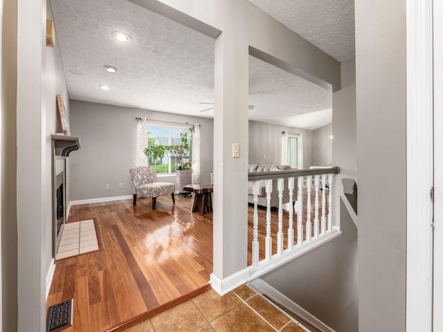 7020 Avery Rd, Dublin, OH 43017 - corridor with a textured ceiling, baseboards, and an upstairs landing