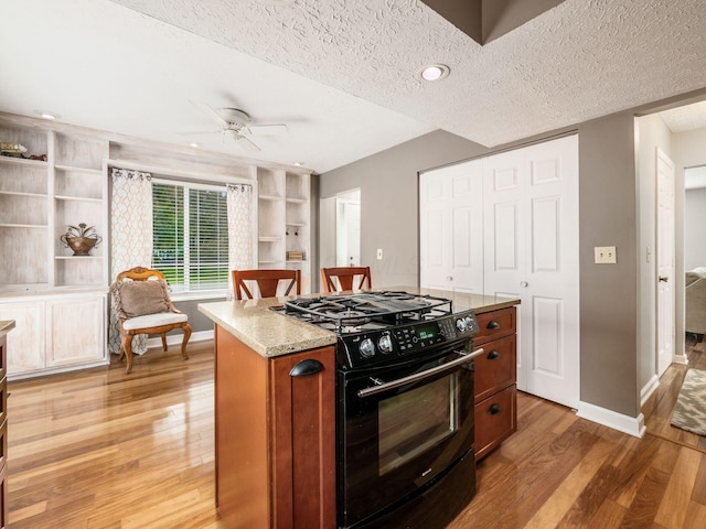 7020 Avery Rd, Dublin, OH 43017 - kitchen featuring black gas stove, light wood-style floors, ceiling fan, a textured ceiling, and baseboards