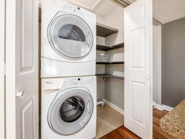 7020 Avery Rd, Dublin, OH 43017 - laundry room with stacked washer / dryer, baseboards, and a textured ceiling