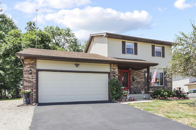 traditional home featuring brick siding, driveway, an attached garage, and a front yard