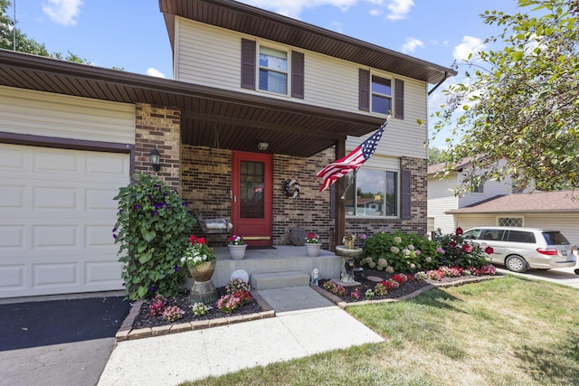 traditional home featuring covered porch, brick siding, a front lawn, and a garage