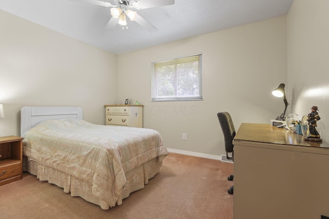 bedroom with light carpet, baseboards, an office area, and ceiling fan