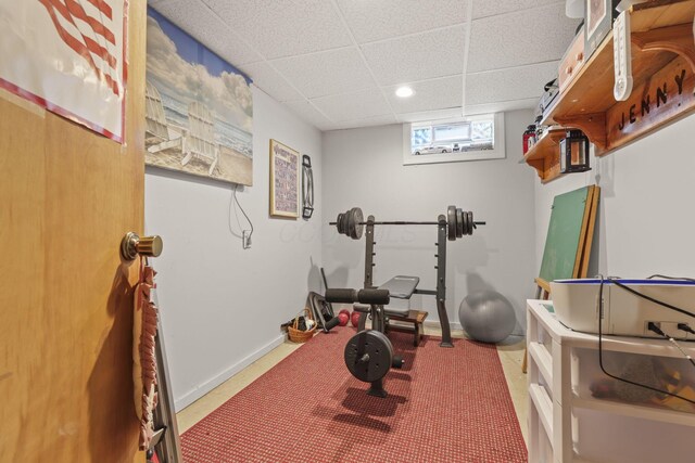 workout room with recessed lighting, a paneled ceiling, and baseboards