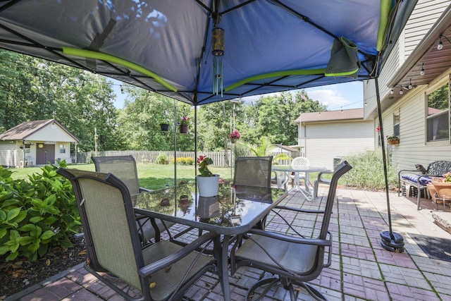 view of patio / terrace featuring outdoor dining space and view of wooded area
