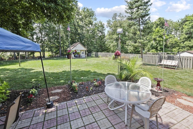 view of patio / terrace featuring outdoor dining space and view of wooded area