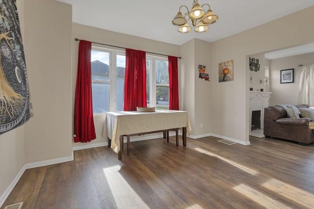 610 W Wheeling St, Lancaster, OH 43130 - dining room with wood finished floors, baseboards, a chandelier, and a brick fireplace
