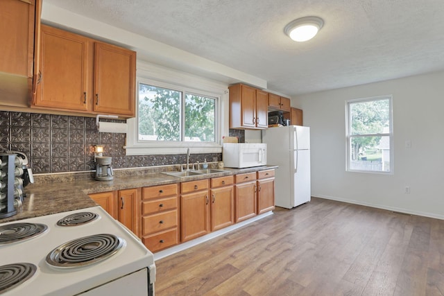 610 W Wheeling St, Lancaster, OH 43130 - kitchen featuring white appliances, a sink, light wood-style floors, a textured ceiling, and tasteful backsplash