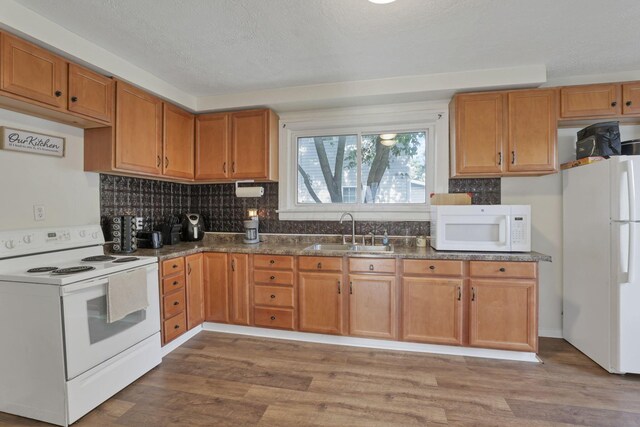 610 W Wheeling St, Lancaster, OH 43130 - kitchen featuring white appliances, a sink, light wood finished floors, decorative backsplash, and brown cabinetry