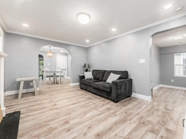 living area with arched walkways, wood finished floors, recessed lighting, baseboards, and a textured ceiling