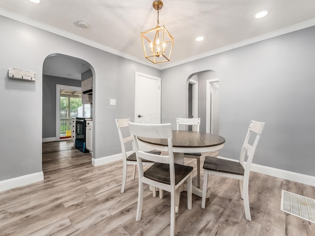 dining room with arched walkways, light wood-style flooring, baseboards, a chandelier, and recessed lighting