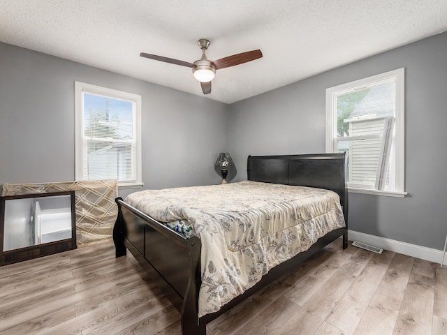 bedroom featuring wood finished floors, baseboards, and ceiling fan