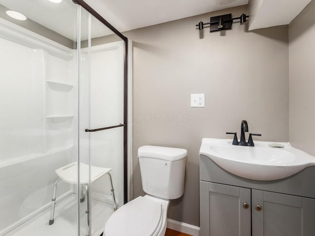 bathroom featuring a stall shower, vanity, and toilet