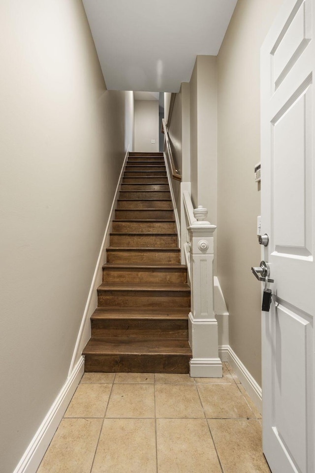 stairway with tile patterned flooring and baseboards