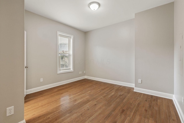 empty room with wood finished floors and baseboards