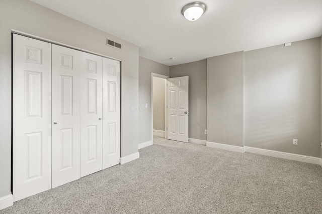 unfurnished bedroom featuring carpet flooring, baseboards, and a closet