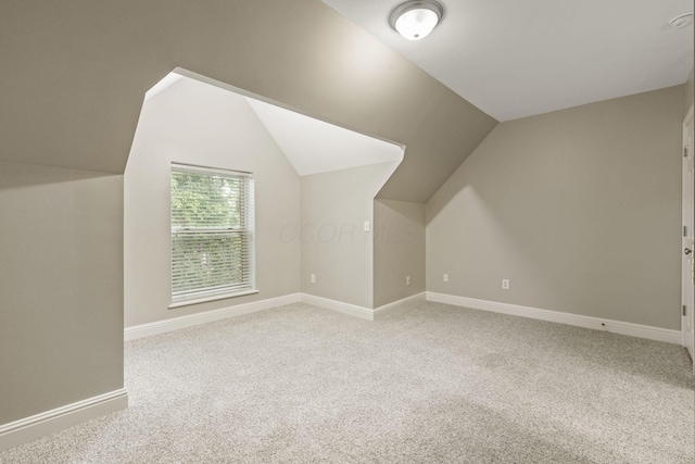 bonus room featuring light carpet, vaulted ceiling, and baseboards