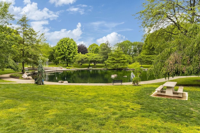 view of home's community with a water view and a yard
